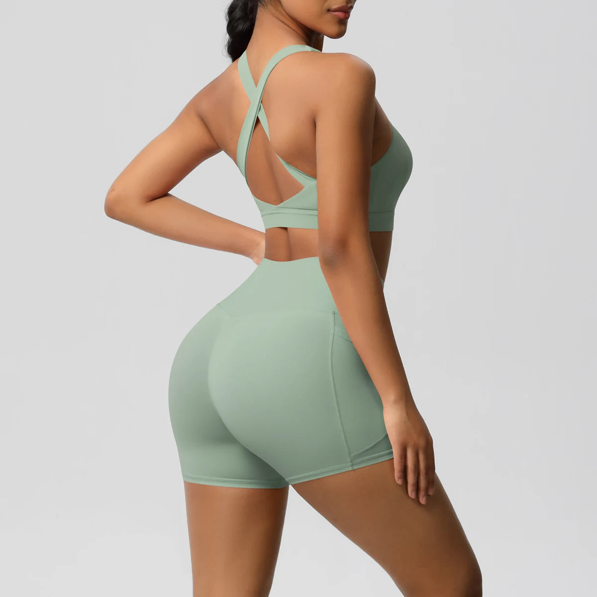 Two-piece women's sportswear yoga set with crossover bra, gym shorts, and leggings in black and gray from The Clothing Company Sydney.