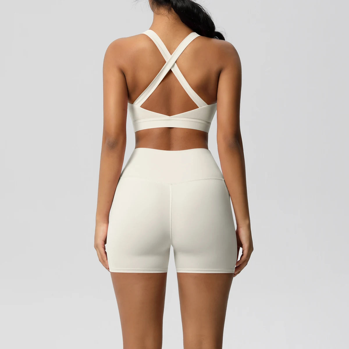 Two-piece women's sportswear set including crossover sports bra, pocketed yoga leggings, and gym shorts from The Clothing Company Sydney.