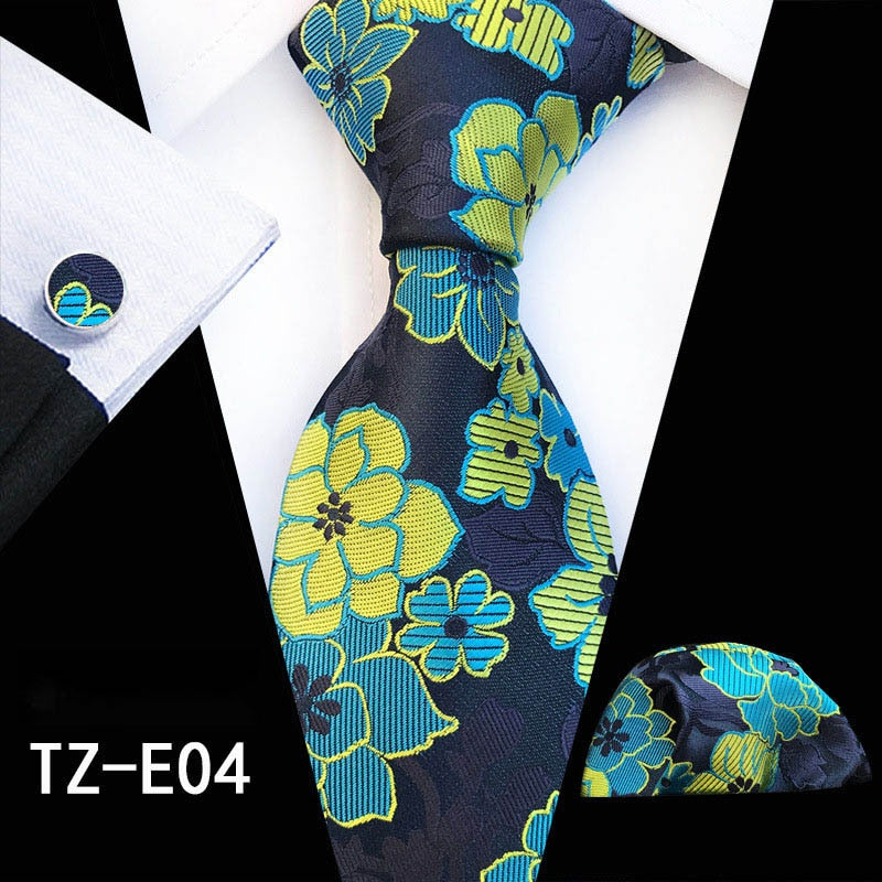 Elegant men's silk tie set with red and green floral handkerchief, cufflinks, and matching necktie for business or wedding occasions.