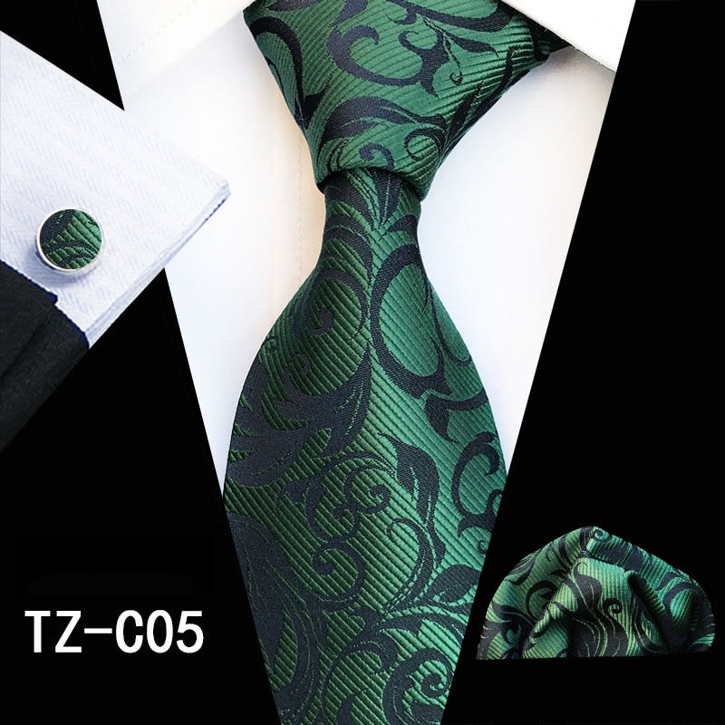 Red and green floral silk men's tie set with matching handkerchief, cufflinks, and necktie for business or wedding attire.