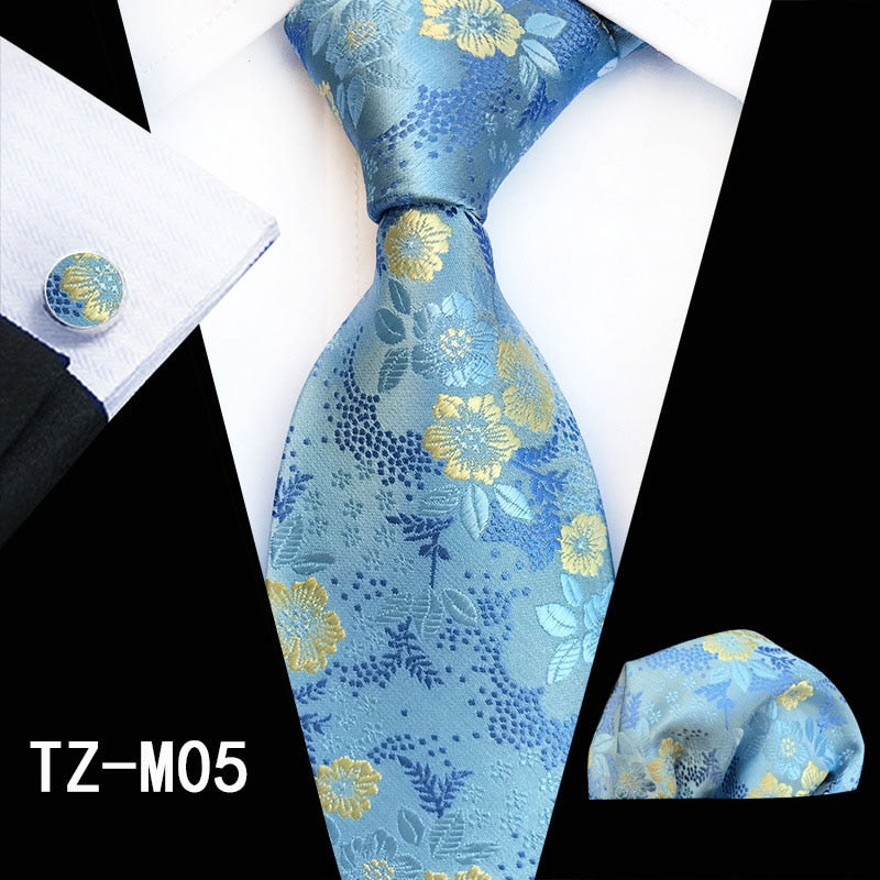 Red and green floral silk tie set with matching handkerchief and cufflinks, stylish accessories for men's business or wedding attire.