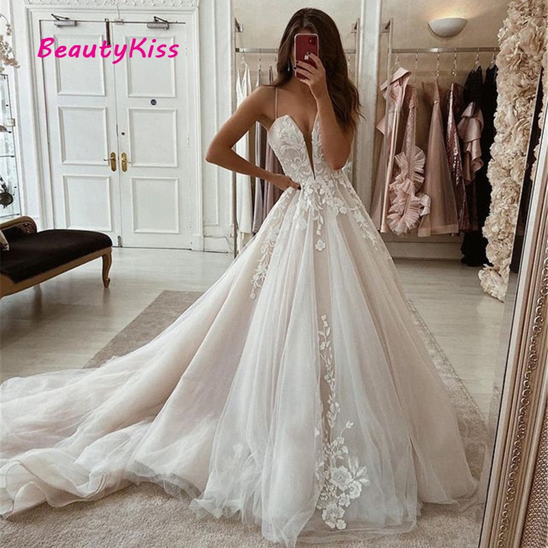 Elegant A-line boho wedding dress with V-neck, lace appliqué, long train, tulle skirt, perfect for beach or princess wedding parties.