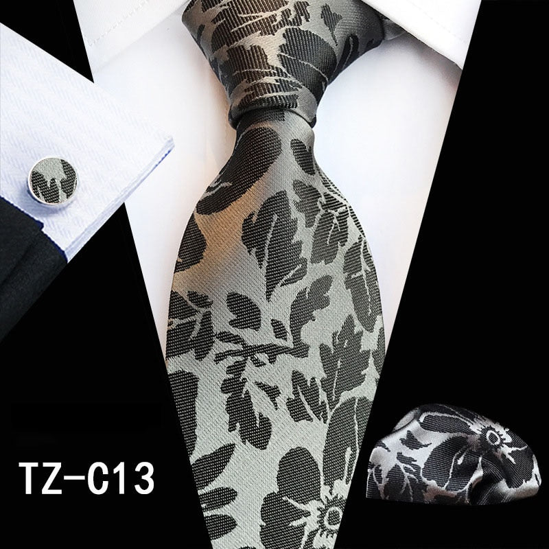 Red and green floral silk tie set with matching handkerchief and cufflinks, stylish men's accessories for business or wedding.
