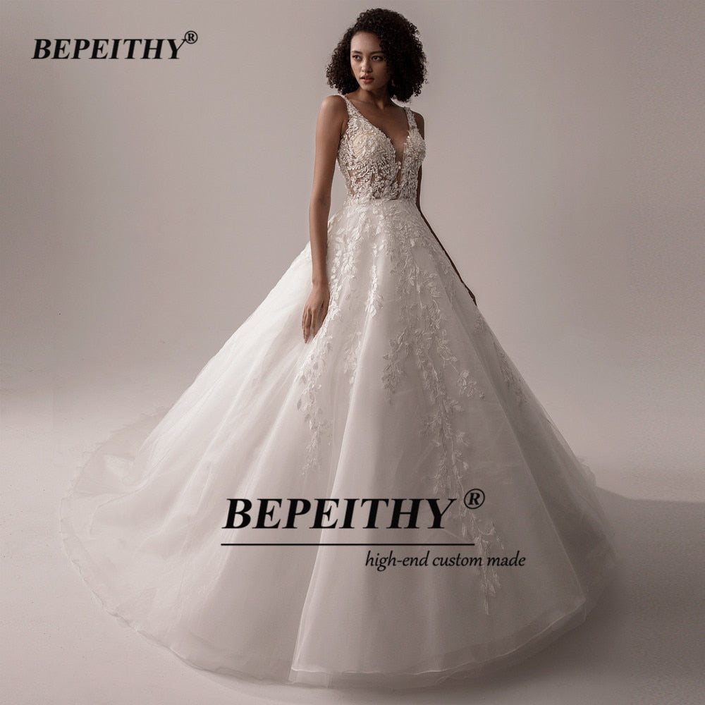 Ivory V-neck sleeveless wedding dress with lace details, A-line silhouette, romantic boho bridal gown by The Clothing Company Sydney