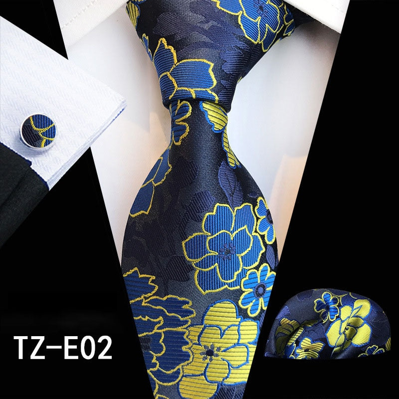 Red and green floral silk tie set with matching handkerchief and cufflinks, suitable for business or wedding suits.