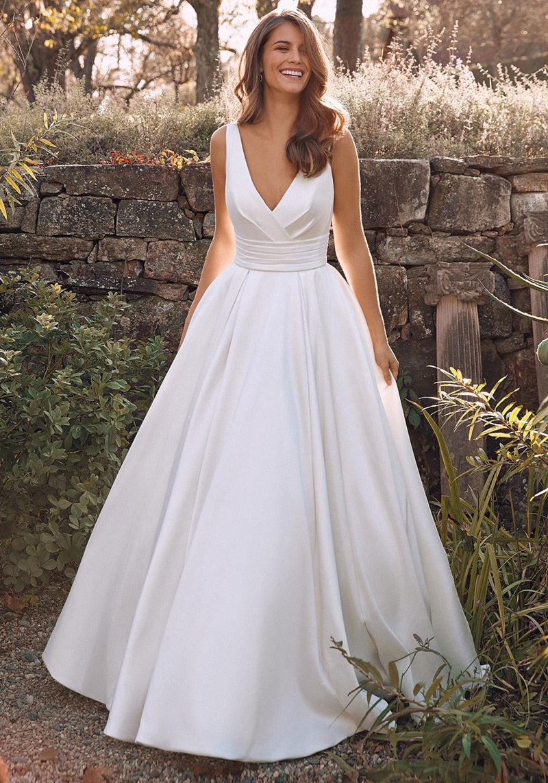 Elegant sleeveless A-line wedding dress with deep V neck and satin fabric, featuring a court train, designed for brides.