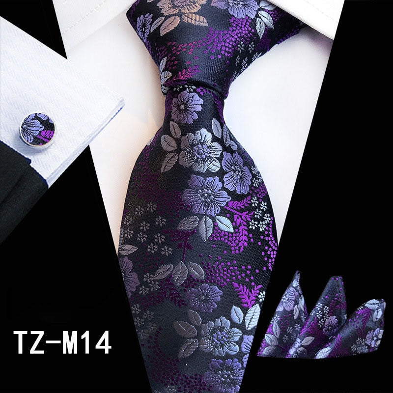 Red and green floral silk tie set with cufflinks, handkerchief, and matching accessories for men's business or wedding attire.