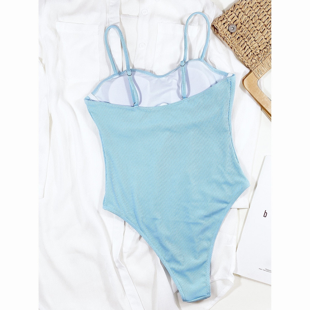 Solid blue one-piece swimsuit by The Clothing Company Sydney featuring a thong design, suitable for beachwear and swimming.