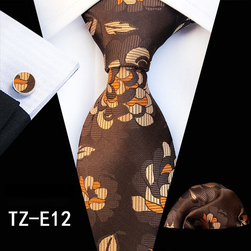Red and green floral men's silk tie set with matching handkerchief, cufflinks, and necktie, ideal for business or wedding attire.