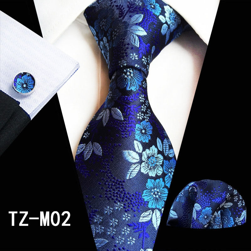 Red and green floral silk tie set with matching handkerchief and cufflinks, perfect for business or wedding attire.