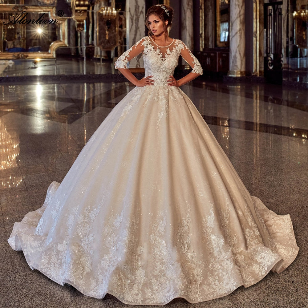 Elegant wedding dress with shiny beading, lace-up back, half sleeves, and puffy ball gown silhouette by The Clothing Company Sydney.