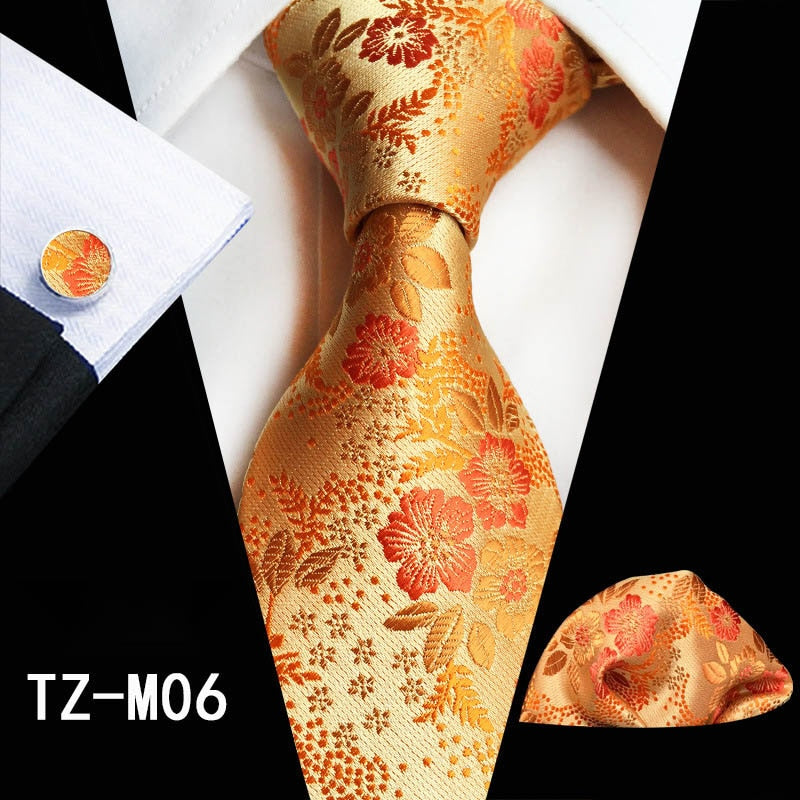 Red and green floral silk tie set with matching handkerchief and cufflinks, stylish accessories for men's business or wedding attire.