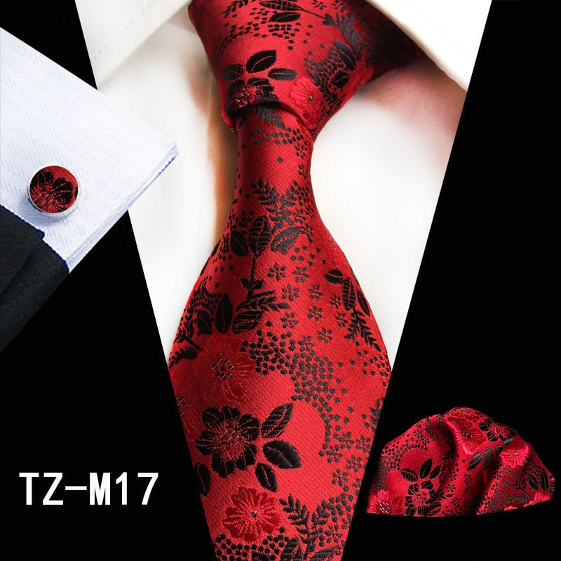 Red and green floral silk tie set with matching handkerchief and cufflinks, stylish accessories for men's business or wedding attire.