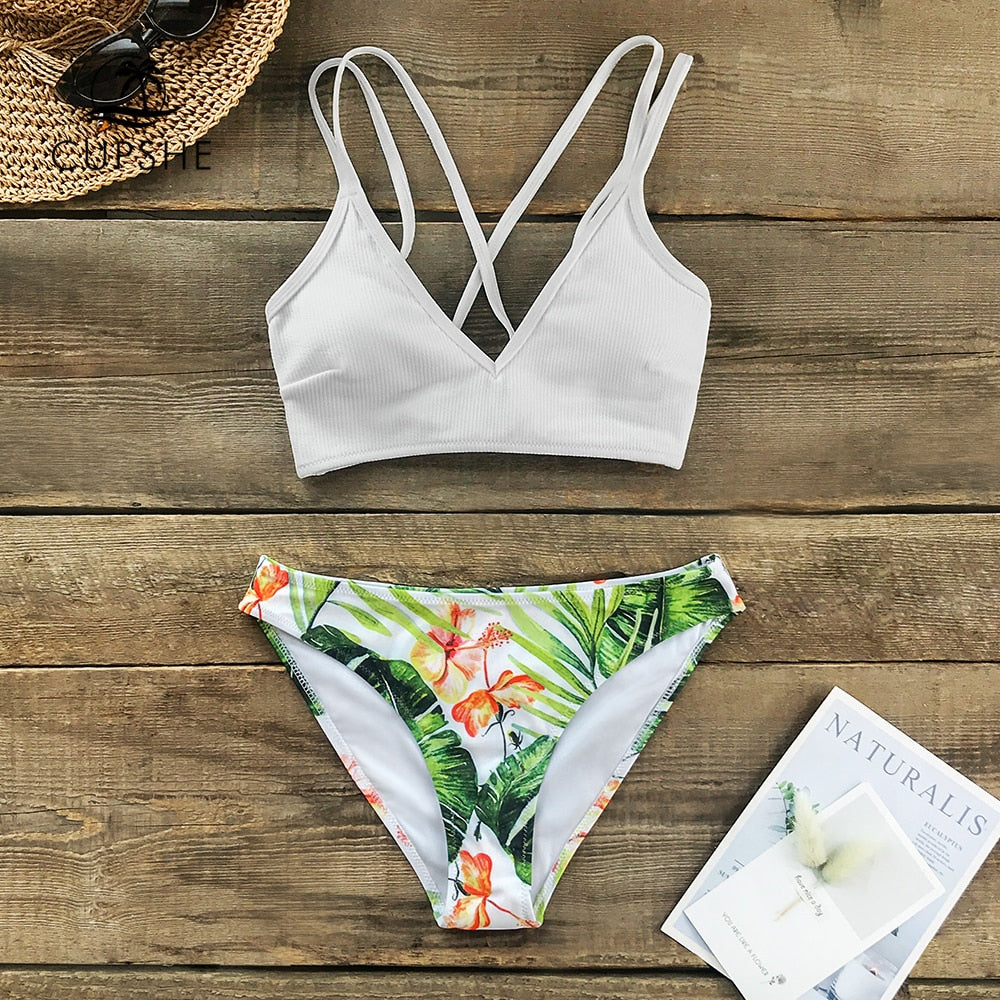 White and green leaf print low-waist bikini set with lace-up front, two-piece swimwear for beach and swimming activities.