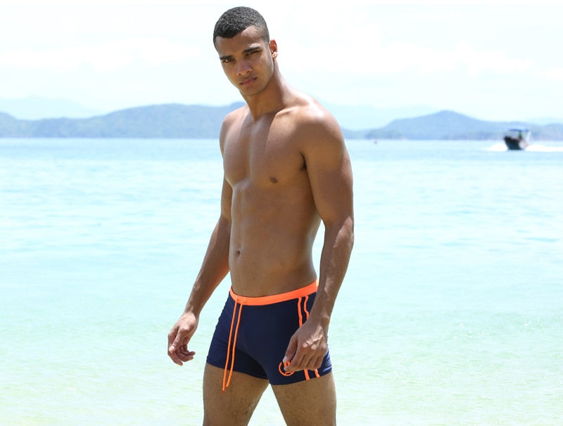 Men's swimming briefs by The Clothing Company Sydney, blue swim trunks with water-themed design, suitable for swimming and beach wear.