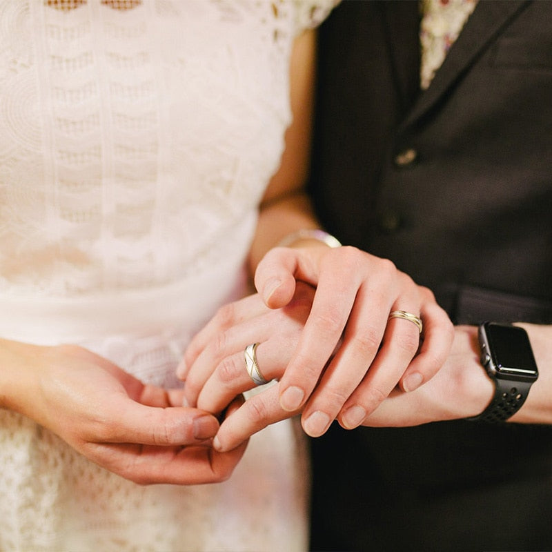 Matte gold stainless steel wedding rings for couples, engraved, designed as matching bracelets for men and women.
