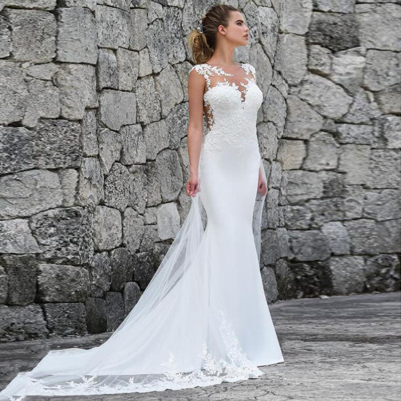 Elegant mermaid wedding dress by The Clothing Company Sydney featuring a see-through back, sleeveless design, and intricate lace appliques.