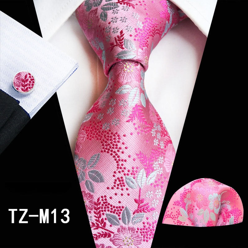 Red and green floral silk tie set with matching handkerchief and cufflinks, perfect for business or wedding suits.