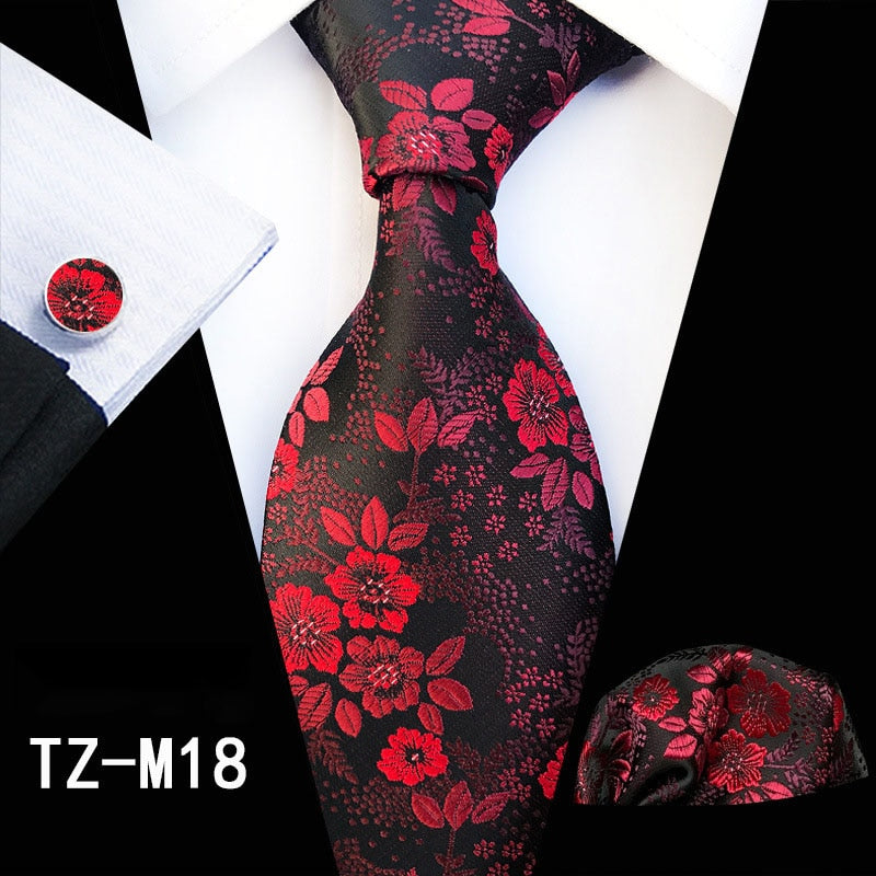 Red and green floral silk tie set with matching handkerchief, cufflinks, and necktie for men's fashion and business suits.