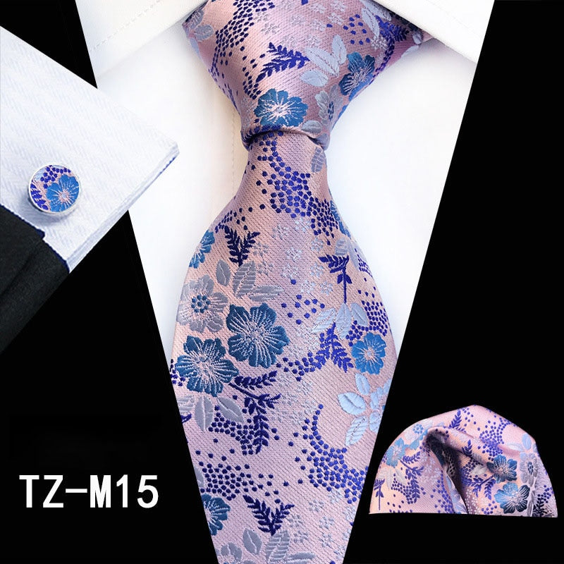 Red and green floral silk tie set including cufflinks, pocket square, and necktie with accessories for men's business or wedding attire.