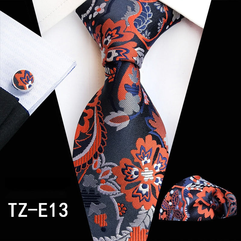 Red and green floral silk men's tie set with matching handkerchief, cufflinks, and necktie, perfect for business or wedding attire.