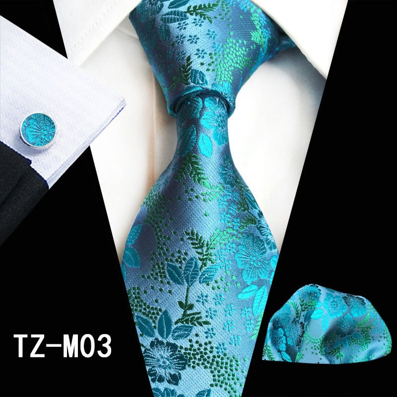 Red and green floral silk tie set with matching handkerchief and cufflinks, stylish accessories for men’s business or wedding attire.