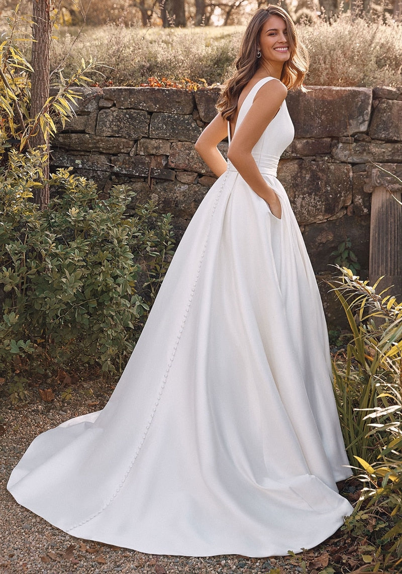 Sleeveless strap A-line wedding dress with deep V neck, simple satin fabric, court train, designed for brides.