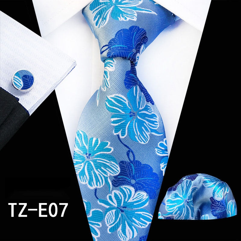 Red and green floral silk tie set including cufflinks, handkerchief, and necktie, with accessories for men's business or wedding attire.