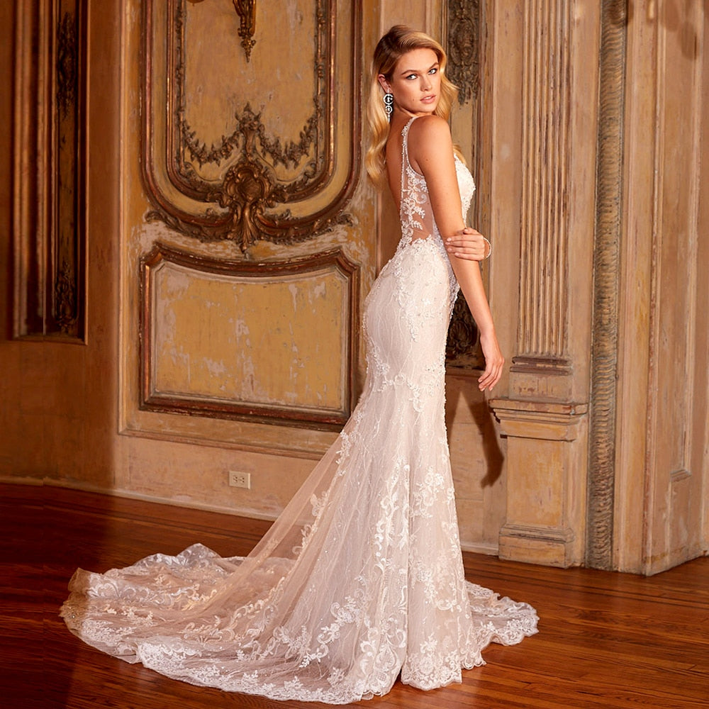 Elegant shiny mermaid wedding dress with V-neck, backless design, lace appliques, and beading by The Clothing Company Sydney.