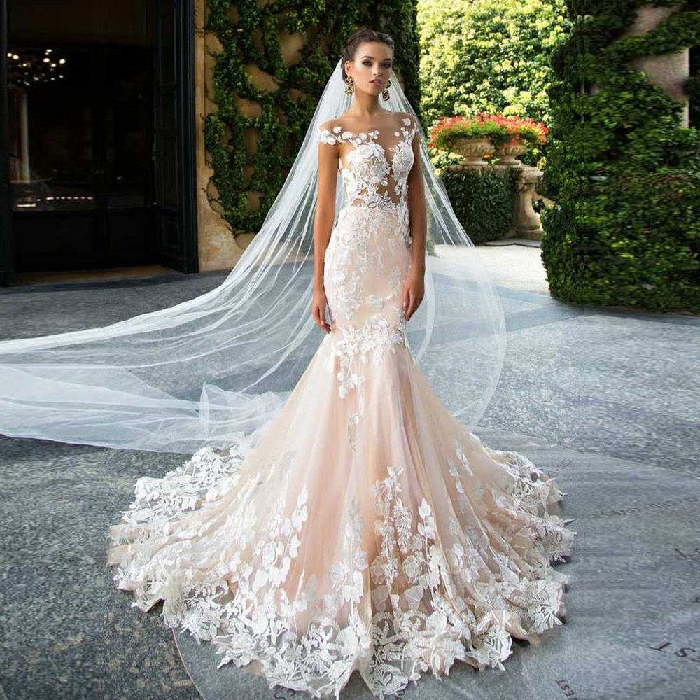 Custom made wedding dress with cap sleeves, backless design, floral appliques, and mermaid silhouette by The Clothing Company Sydney.