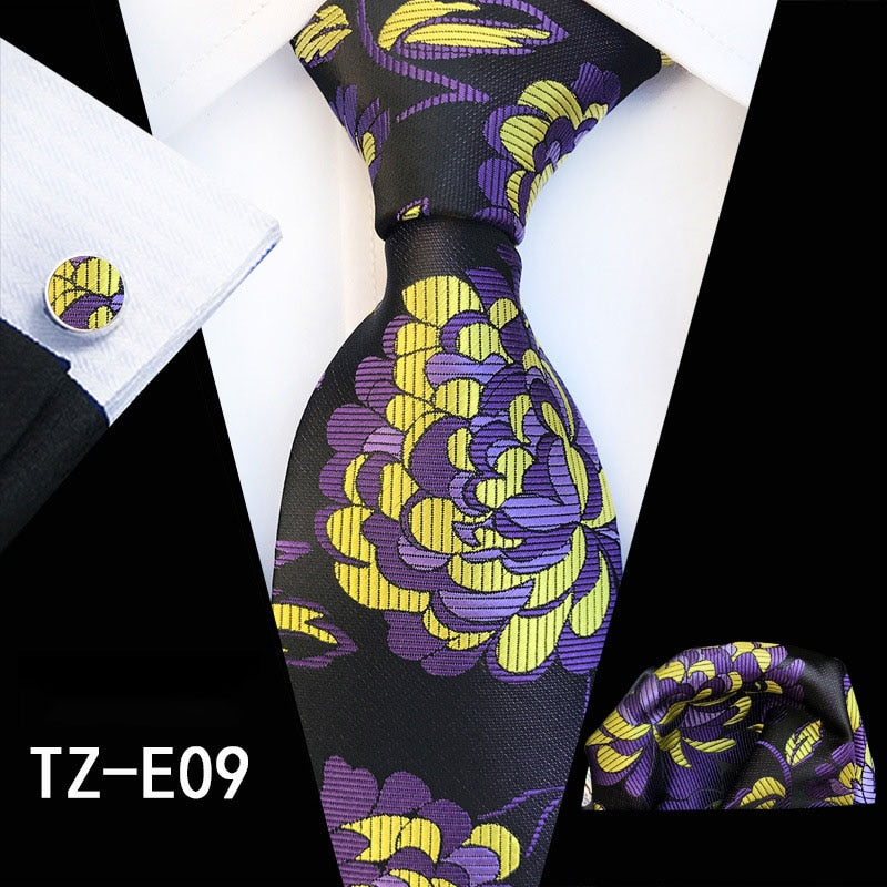 Red and green floral silk tie set with matching handkerchief and cufflinks, stylish accessories for business or wedding attire.
