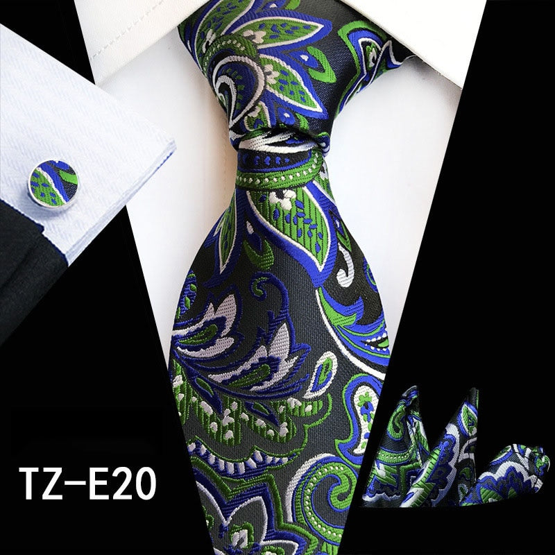 Elegant men's silk tie set with red and green floral pattern, matching handkerchief and cufflinks for business or wedding attire.