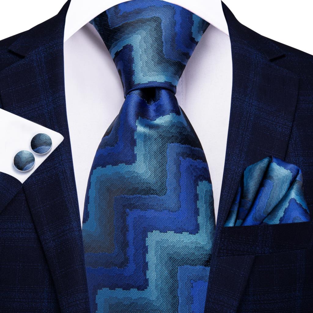 Blue silk men's business tie with dot pattern, plaid cufflinks, and matching accessories for wedding or professional attire.