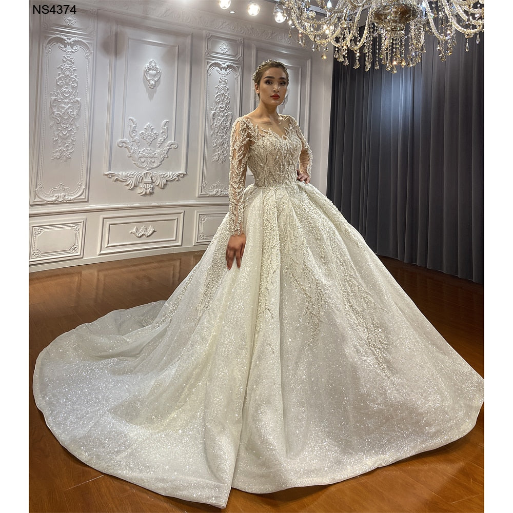 Elegant long sleeve ball gown wedding dress by The Clothing Company Sydney, featuring a fitted bodice and flowing skirt.