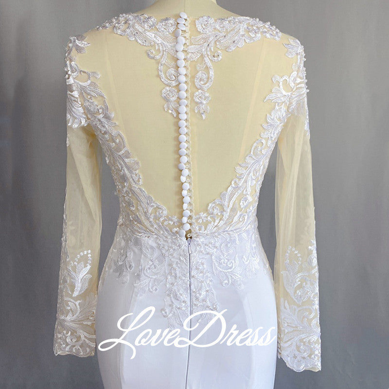 Elegant mermaid wedding dress by The Clothing Company Sydney with long sleeves, illusion back, lace appliqué, buttons, and train.