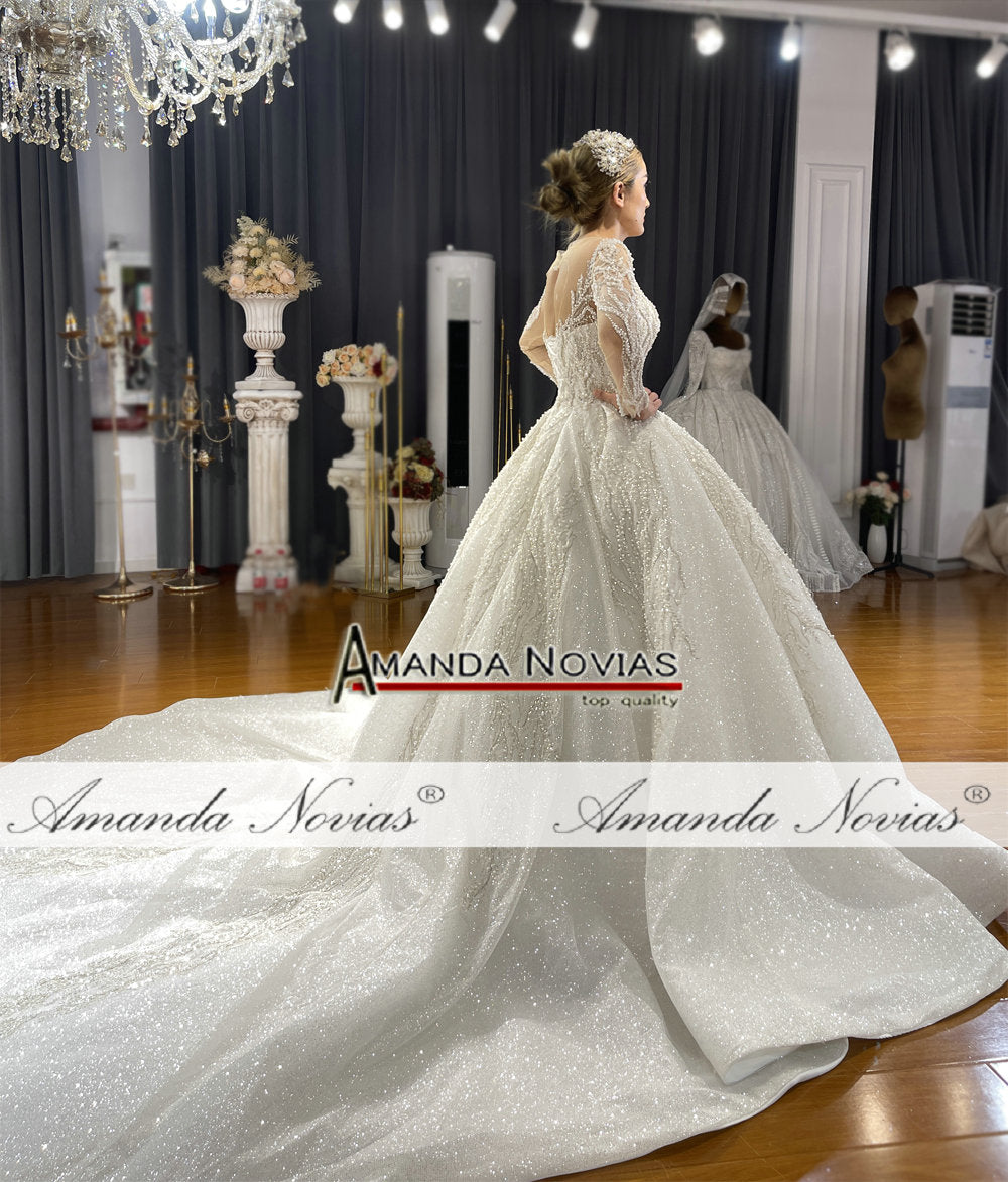 Elegant long sleeve wedding gown by The Clothing Company Sydney featuring a flowing ball gown silhouette and intricate lace details.