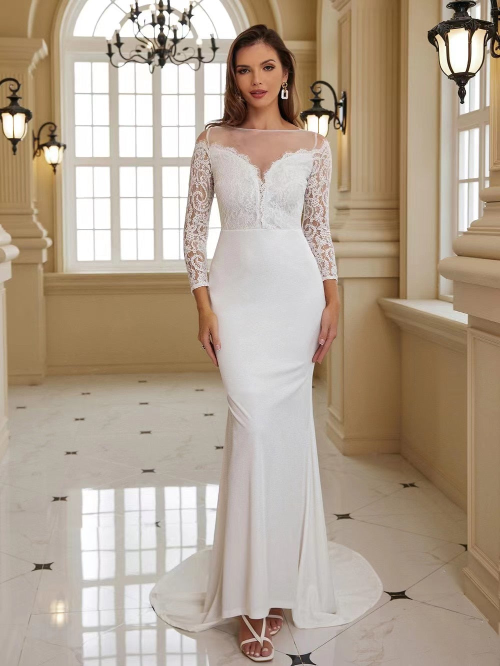 Elegant white wedding dress with long sleeves and a long train, featuring intricate details and a fitted bodice.