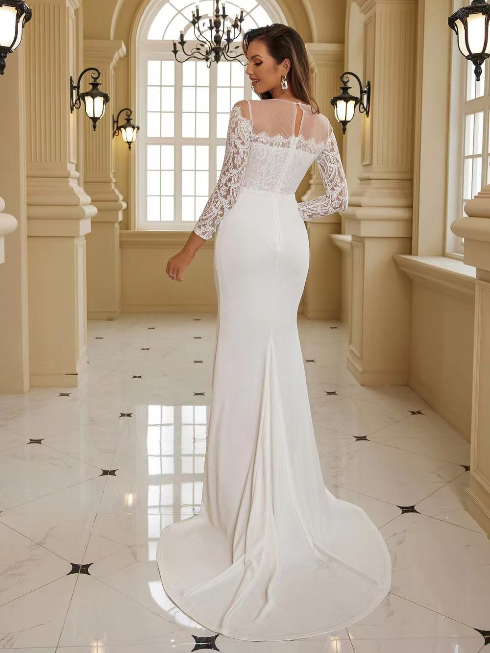 Elegant white wedding dress with long sleeves, a flowing train, and intricate details, designed for brides from The Clothing Company Sydney.