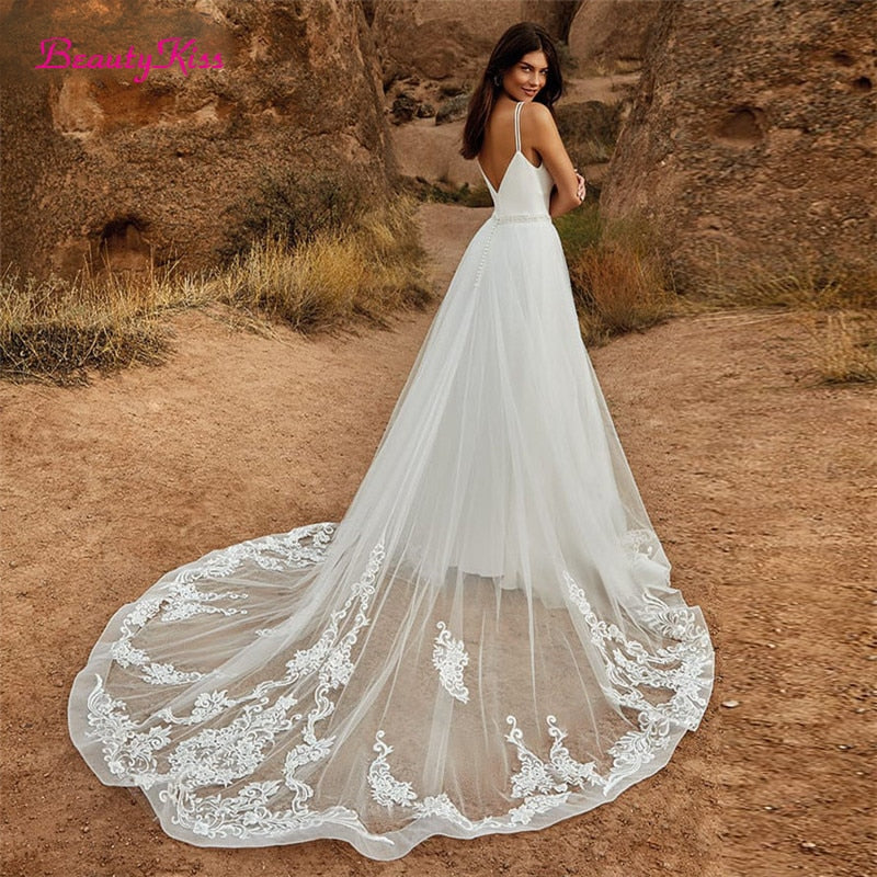 Elegant 2-in-1 wedding jumpsuit with detachable skirt, tulle fabric, V-neck, and sweep train, by The Clothing Company Sydney.