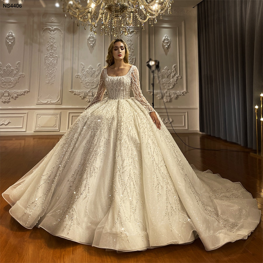 Long sleeve luxury beaded bridal wedding dress with intricate beadwork and elegant fit, designed by The Clothing Company Sydney.