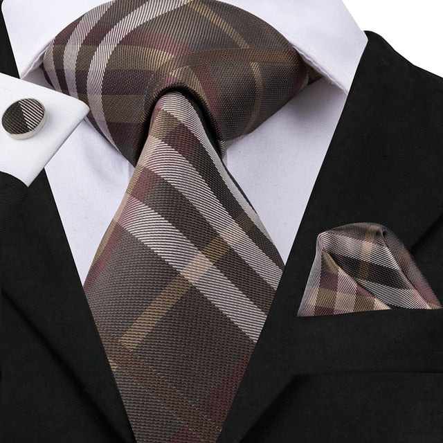 Set of men's accessories including a blue and black striped silk necktie, pocket square, cufflinks, all in classic style.