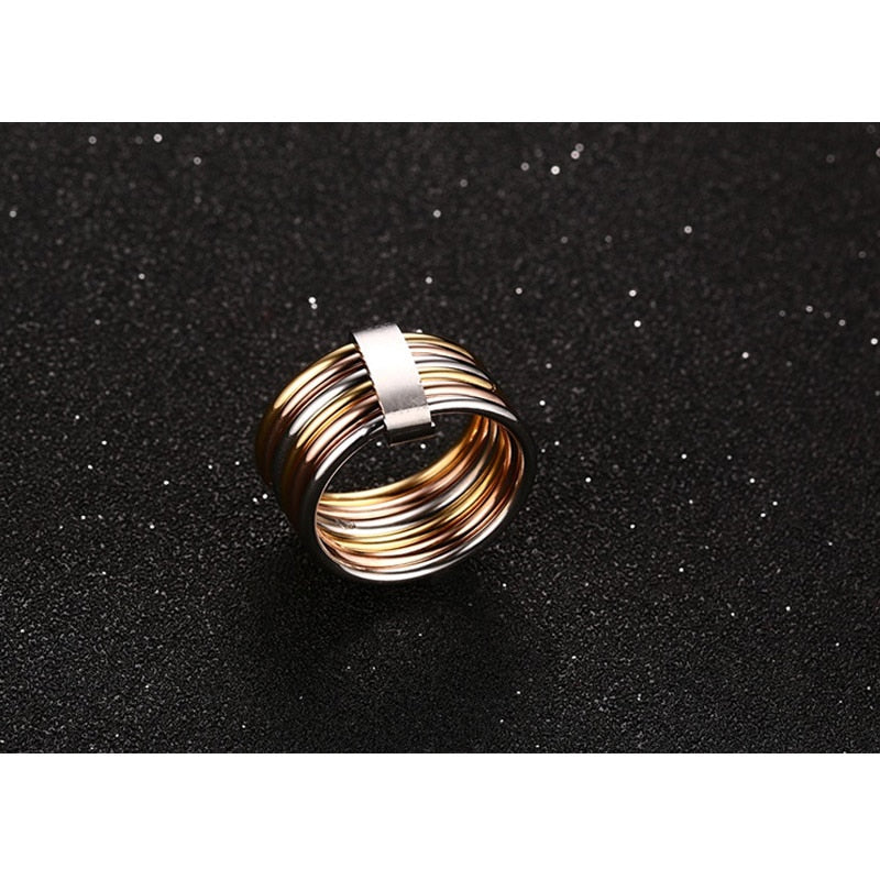 Stacked wide statement cocktail rings with six interlocked plain bands in three colors, designed for women.