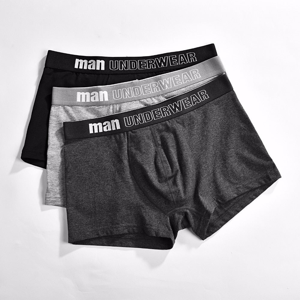 Four pairs of men's cotton boxer briefs from The Clothing Company Sydney, featuring breathable, solid-colored, flexible underwear shorts.
