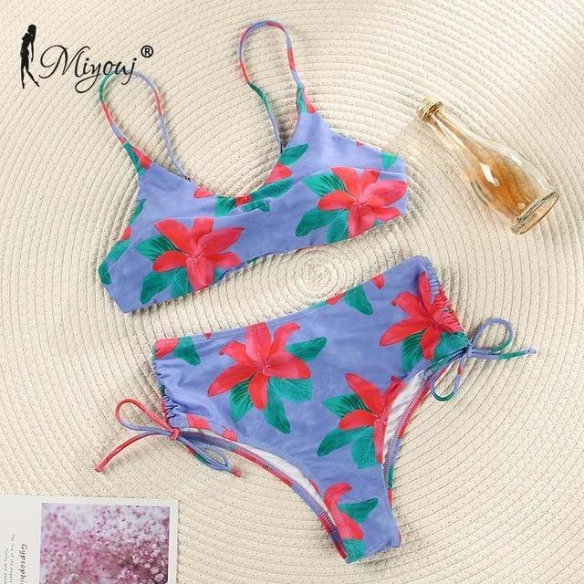 Deep V neck floral print bikini swimsuit with bow detail and lace-up design by The Clothing Company Sydney on a model.