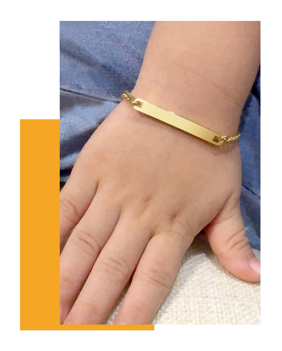 Gold-tone stainless steel personalized baby name bracelet with adjustable fit from The Clothing Company Sydney, featuring custom engraving.