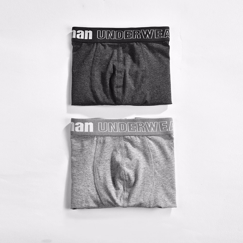 Four pairs of men's cotton boxer briefs from The Clothing Company Sydney, featuring breathable and flexible solid-colored shorts.