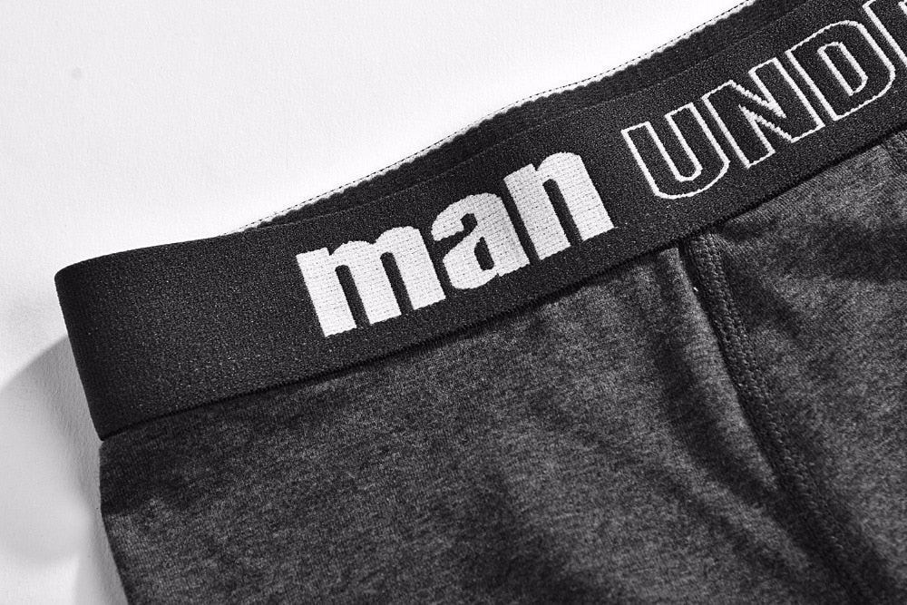Four pairs of men's cotton boxer briefs from The Clothing Company Sydney, featuring solid colors and breathable, flexible fabric.
