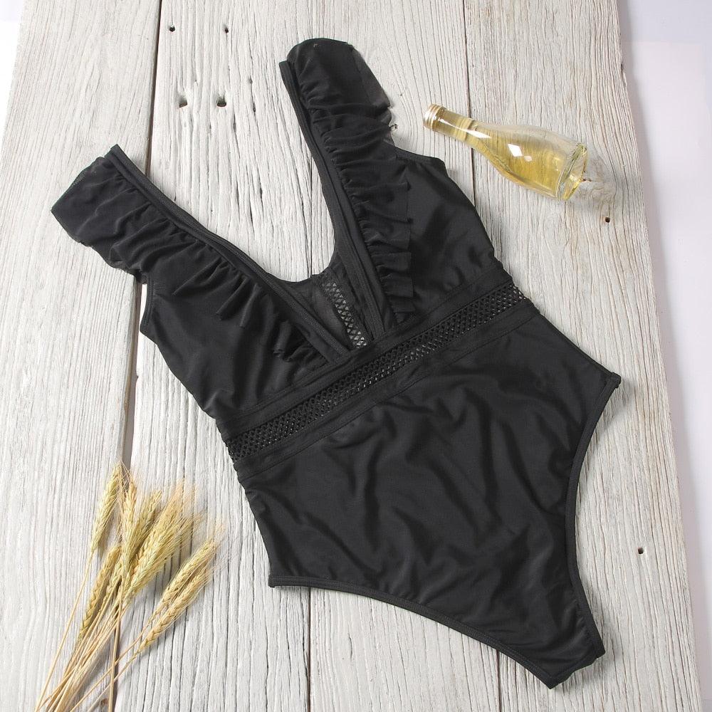 Purple and black floral one-piece swimsuit with v-neck, ruffle details, from The Clothing Company Sydney, featuring a stylish monokini design.