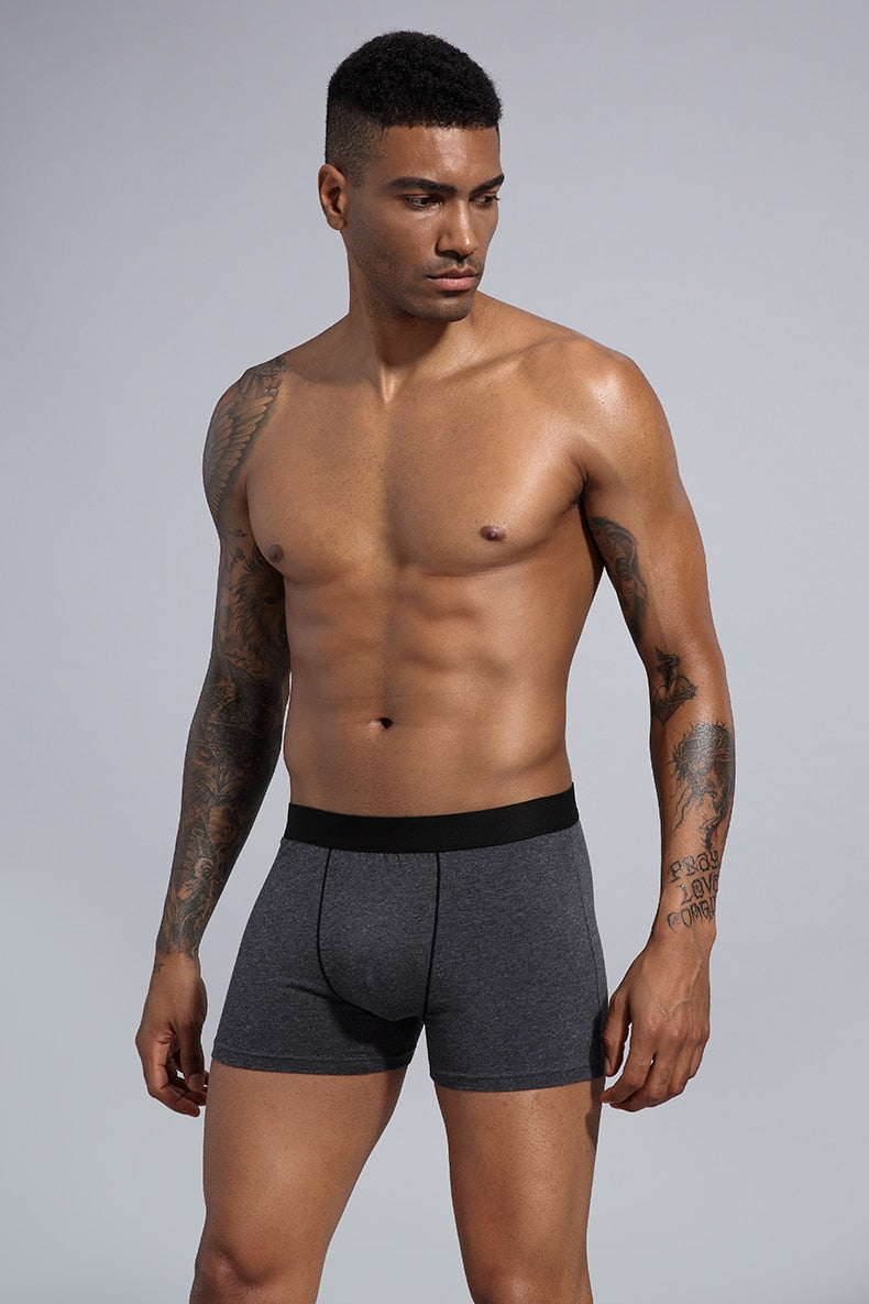 Four men's cotton boxer shorts in various colors from The Clothing Company Sydney, displayed in a pack.
