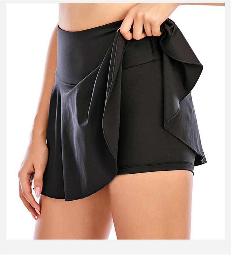 Gray 2-in-1 sports gym skirt with built-in shorts and pleated tennis skirt design, suitable for running, yoga, and fitness activities.